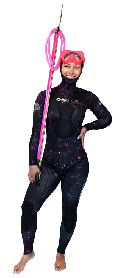 Person wearing a black wetsuit with pink accents and a helmet, holding a pink tool on a white background.